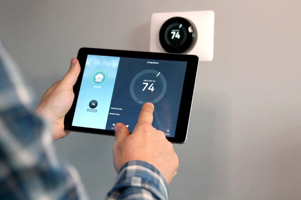 Man adjusting smart thermostat via tablet