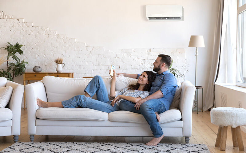 Young couple enjoying air conditioned living room